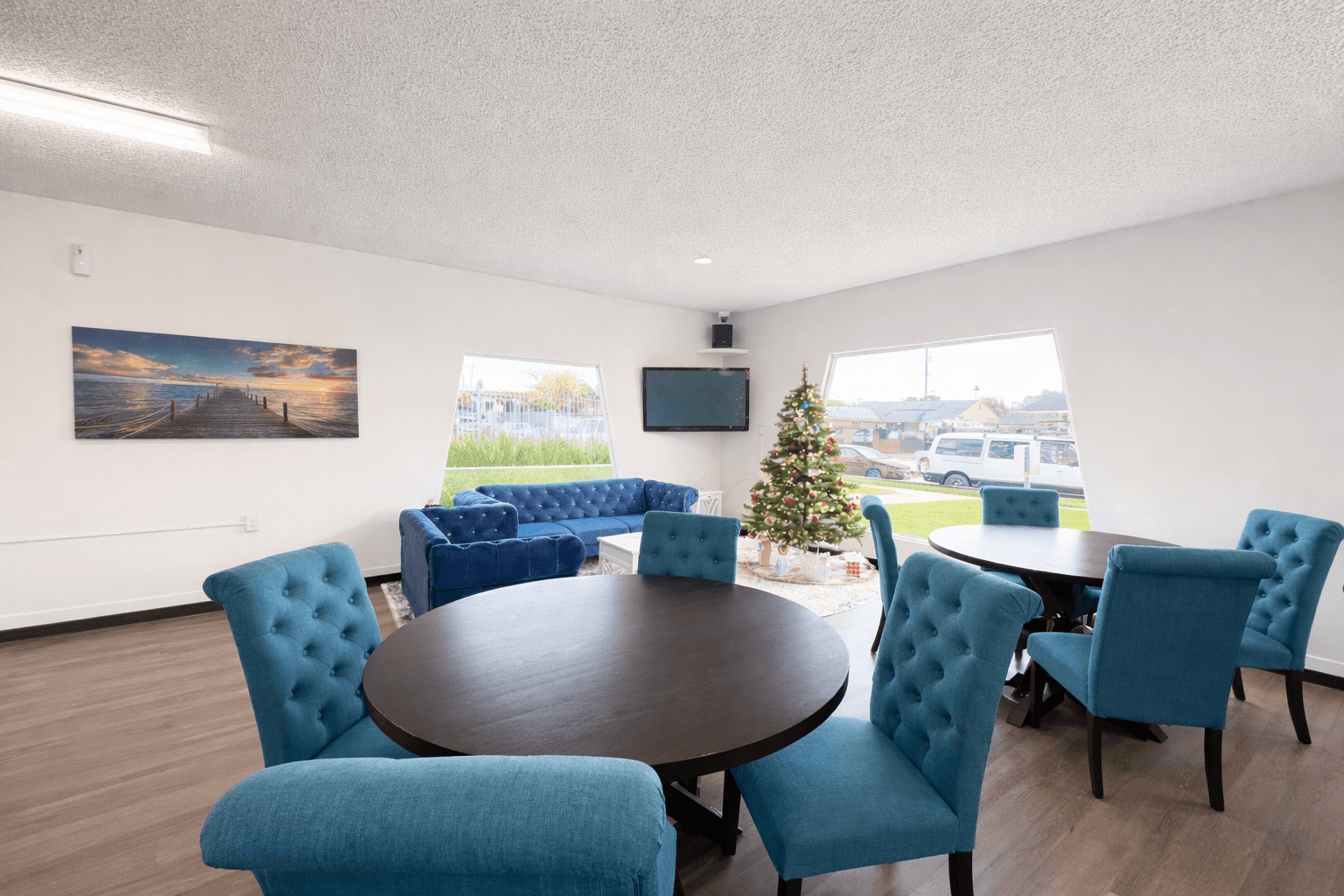 A room with a round table surrounded by blue chairs.